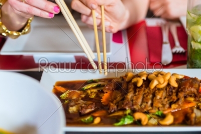 Young people eating food in Thai restaurant