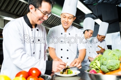 Asian Chef in restaurant kitchen cooking