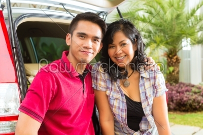 Asian couple is happy in front the car