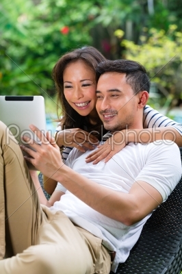 Asian couple outdoor with a tablet pc