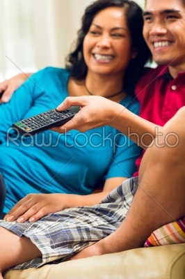 Asian couple watching tv