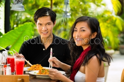 Asian man and woman in restaurant