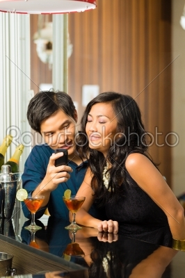 Asian man is flirting with woman in bar