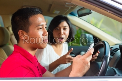 Asian man texting while driving