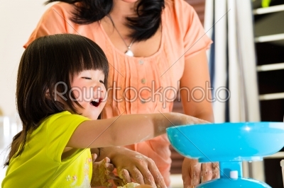Asian Mother and daughter at home in kitchen