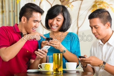 Asian people having fun with mobile phone