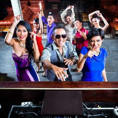 Asian people partying on dance floor in nightclub