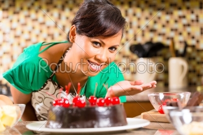 Asian woman baking  chocolate cake in kitchen