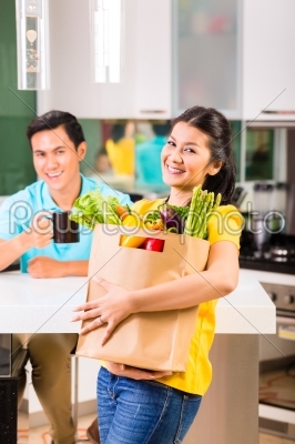 Asian woman coming home from grocery shopping