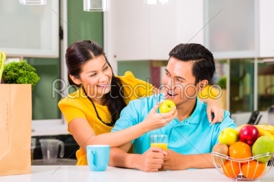 Asian woman feeding boyfriend with apple 
