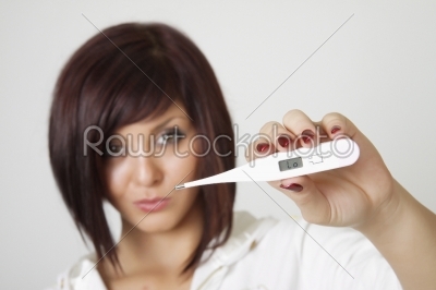 Attractive Caucasian female checking her temperature 