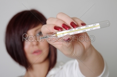 Attractive Caucasian female checking her temperature