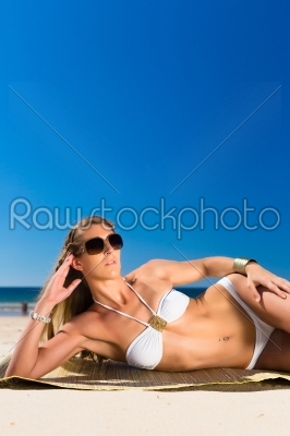 Attractive woman lying in the sun on beach