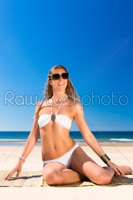 Attractive woman sitting in the sun on beach