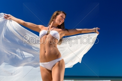 Attractive woman stands in the sun on beach