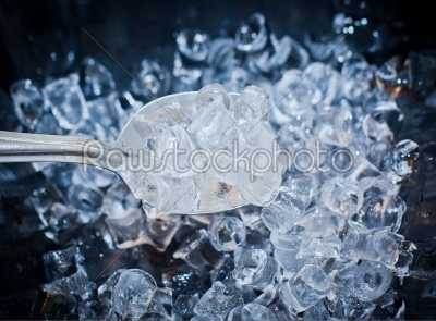 background with ice cubes and spoon in blue light 