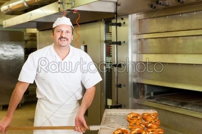 Baker in his bakery baking bread