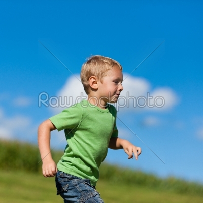 Boy running down a meadow