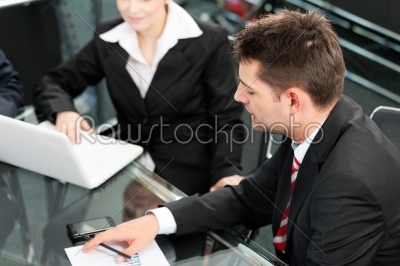 Business people - team meeting in an office with laptop