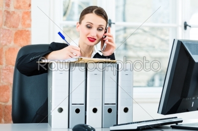 businesswoman in office makes notes in a file