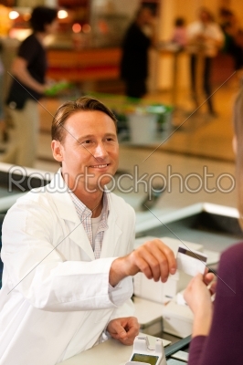 Cashier in supermarket taking credit card