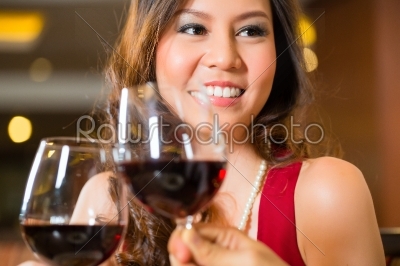 Chinese woman red wine in fancy restaurant