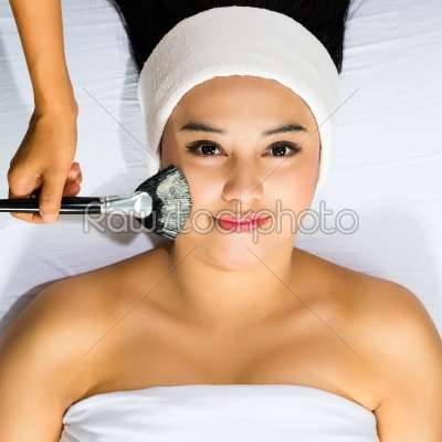 Cosmetics - Asian woman gets a facial mask