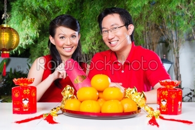 Couple celebrate Chinese new year traditional with gift, wearing red shirts