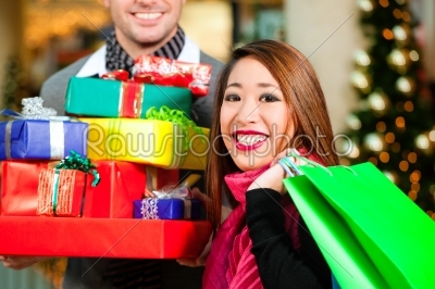 Couple Christmas shopping with presents in mall