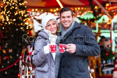 Couple drinking spiced wine on Christmas market
