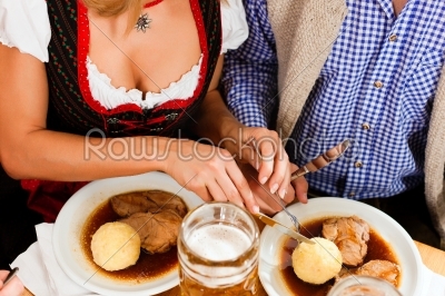 Couple eating roast pork in Bavarian restaurant