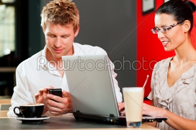 Couple in coffeeshop with laptop and mobile