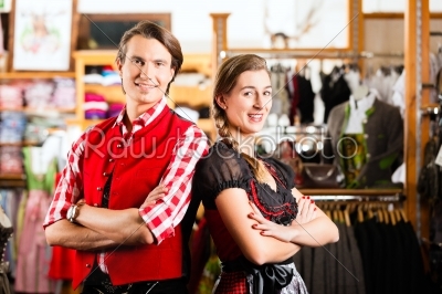 Couple is trying Dirndl or Lederhosen in a shop