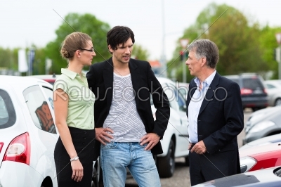 Couple looking at car on yard of dealer