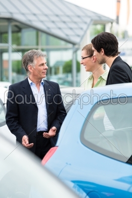 Couple looking at car on yard of dealer