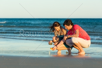 Couple looking for shells at sunset
