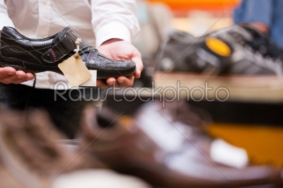 Customer Holding Fashionable Shoe at Supermarket