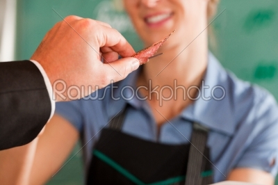 Customer Taking a Piece of Meat from Butcher