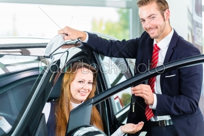 Dealer, female client and auto in car dealership