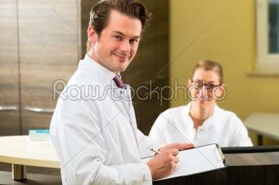 Dentist with clipboard in his surgery
