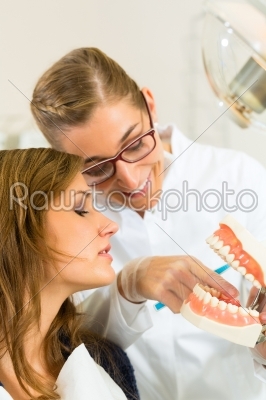 Dentist with toothbrush, denture, and patient