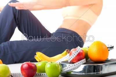 Diet and sport - young woman is doing sit-ups