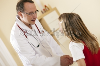 Doctor - Pediatrician - with a child patient in his practice, both are shaking hands