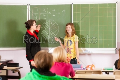 Education - teacher with pupil in school teaching