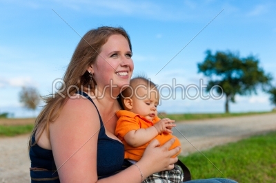 Family - mother and child sitting on a meadow