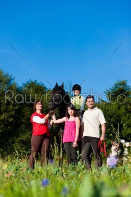 Family and children posing with horse