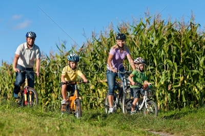 Family is cycling in summer