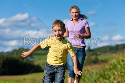 Family outdoors is running on a meadow