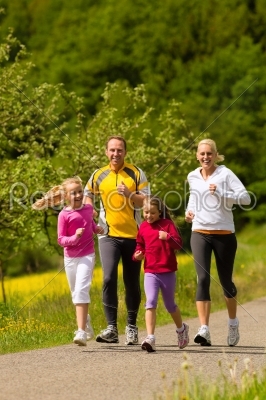 Family running in the meadow for sport