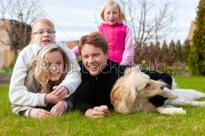 Family sits together on a meadow